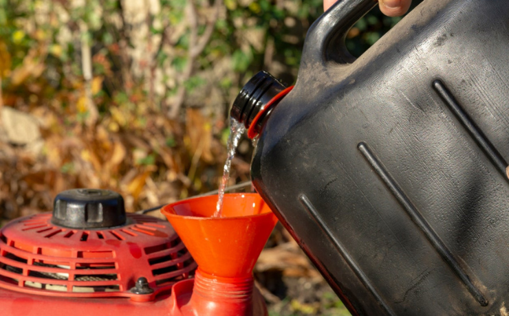 filling up a lawn mower with fuel 