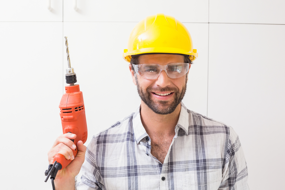 Construction worker holding power drill in a new house-1